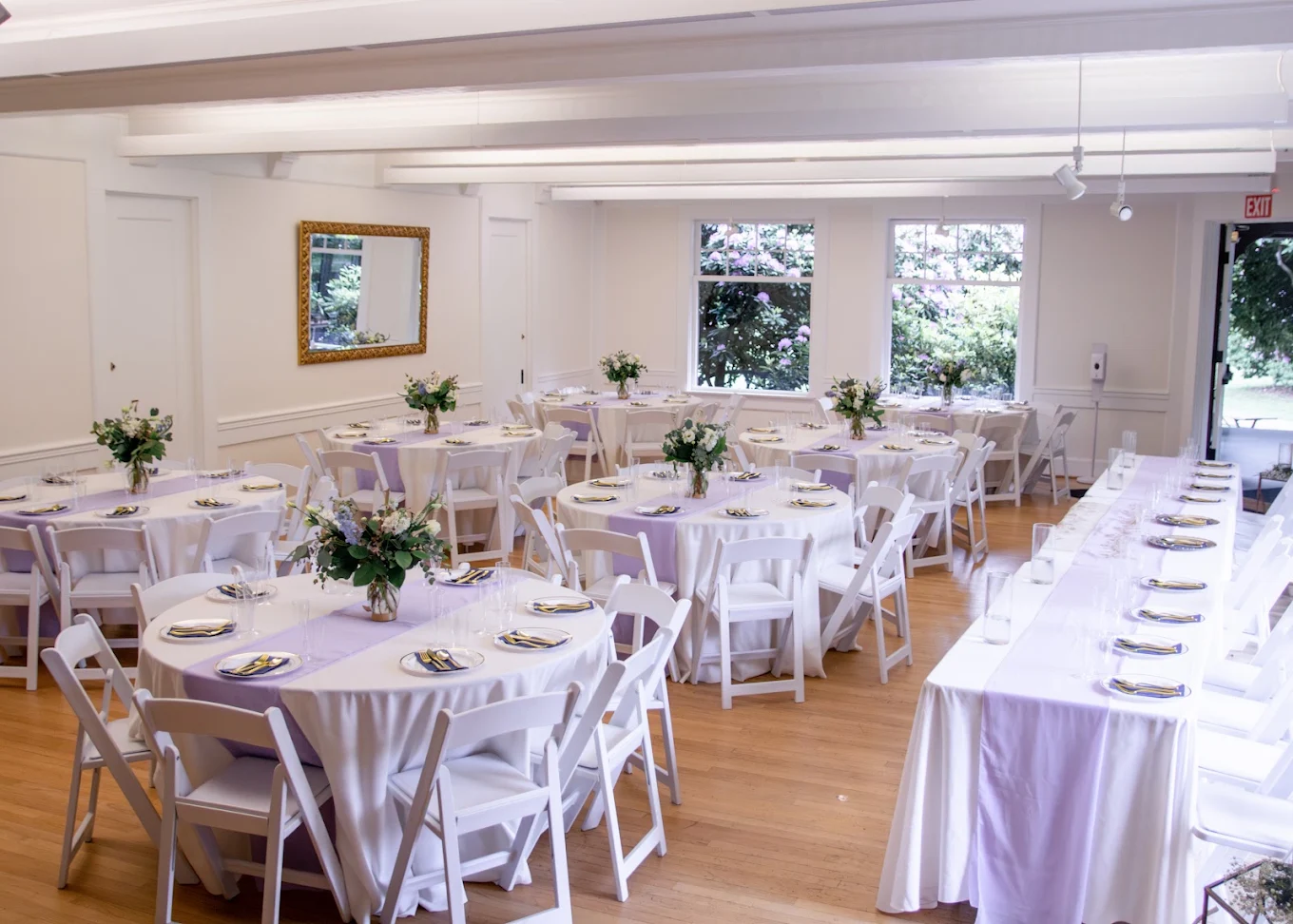 Wedding reception room set with round and long tables in white and lavender linens