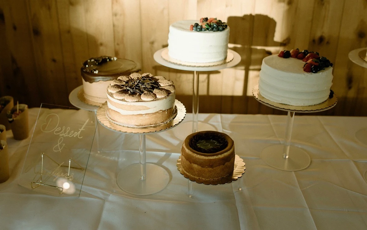 Dessert table with four tiered cakes topped with fresh berries