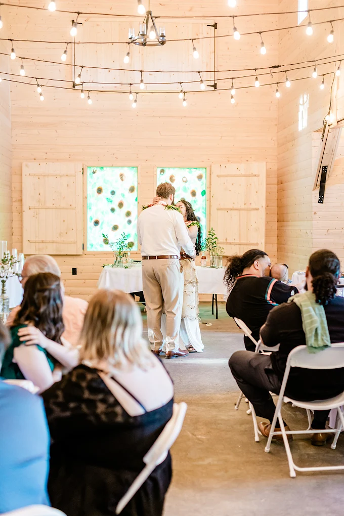 Indoor wedding ceremony with a stained-glass-style backdrop and string lights